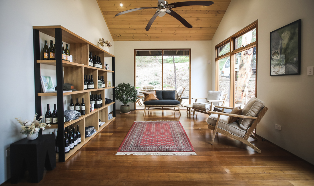 Room with shelves with wines and couches 